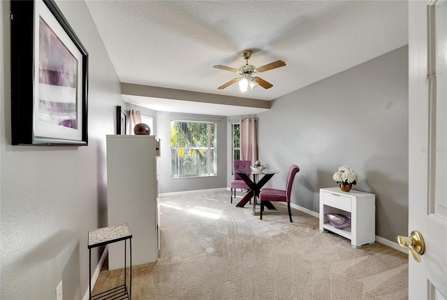 sitting room featuring light carpet, ceiling fan, and a textured ceiling