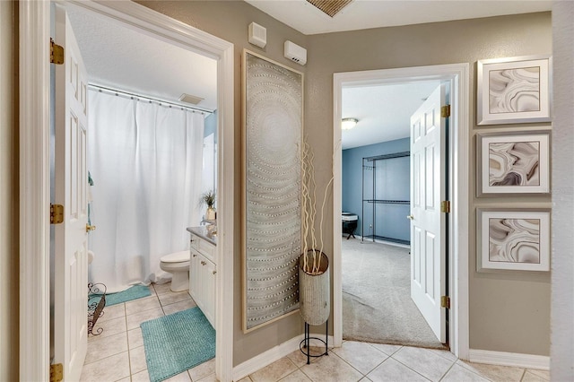 bathroom with tile patterned flooring, vanity, toilet, and curtained shower