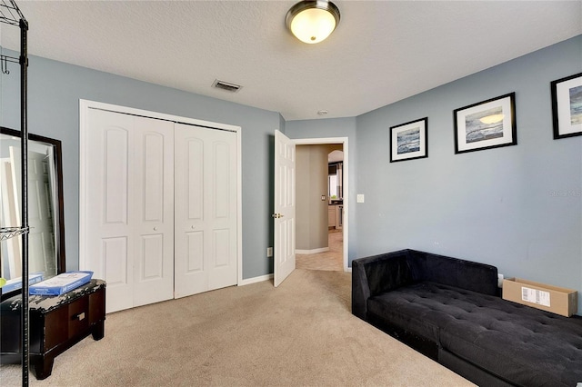 living area with light carpet and a textured ceiling