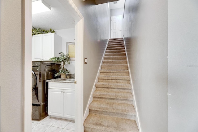 staircase featuring tile patterned flooring and washing machine and clothes dryer