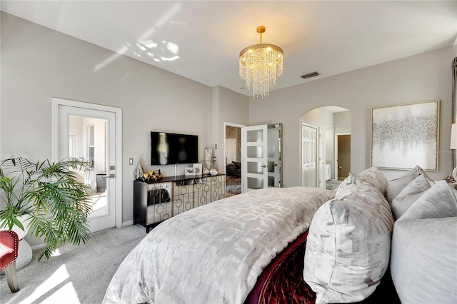 bedroom featuring light colored carpet and an inviting chandelier