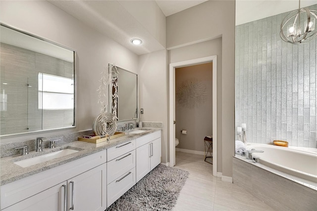 bathroom featuring an inviting chandelier, tile patterned flooring, a bath, toilet, and vanity