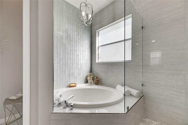 bathroom with a notable chandelier and shower with separate bathtub