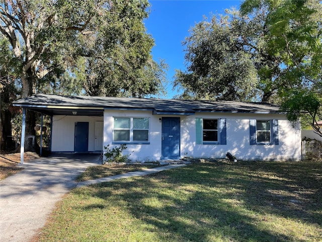 ranch-style home with a carport and a front lawn