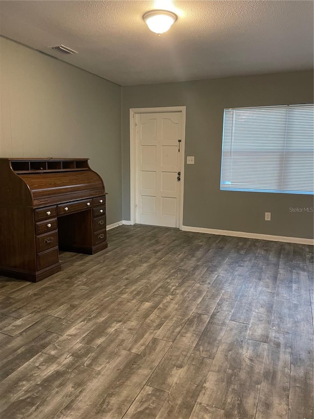 interior space featuring dark wood-type flooring and a textured ceiling