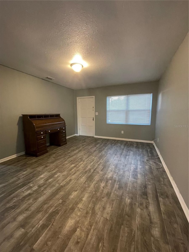 interior space with a textured ceiling and dark wood-type flooring