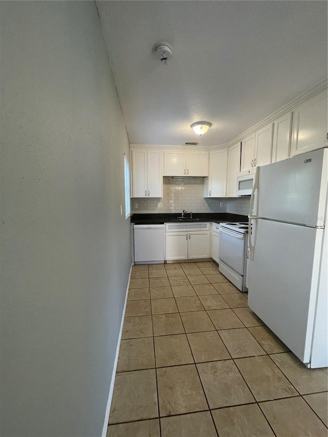 kitchen with white cabinetry, sink, white appliances, decorative backsplash, and light tile patterned flooring