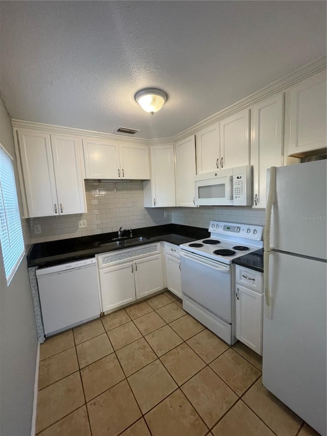 kitchen featuring backsplash, white appliances, sink, light tile patterned floors, and white cabinetry