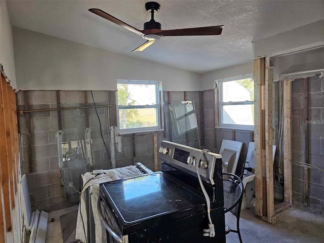 interior space with ceiling fan, washer / dryer, plenty of natural light, and a textured ceiling