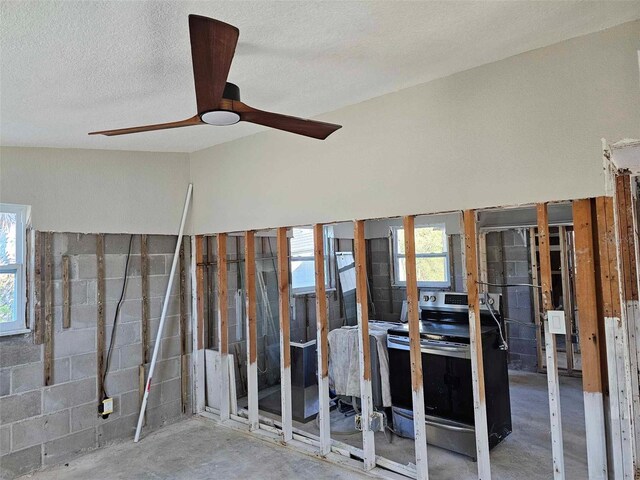 miscellaneous room with ceiling fan, concrete floors, and a textured ceiling