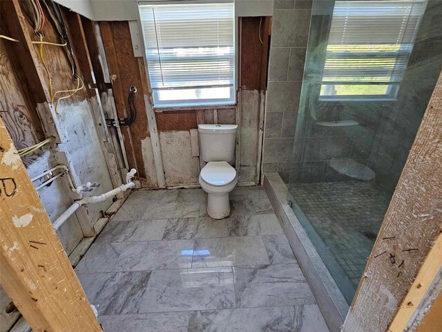 bathroom featuring toilet and a tile shower