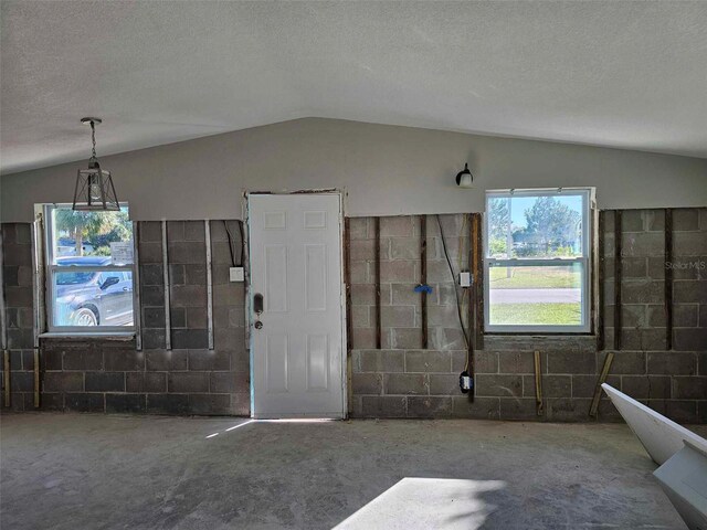 foyer with vaulted ceiling and a textured ceiling