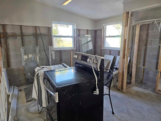 washroom featuring washer / dryer, a textured ceiling, and plenty of natural light