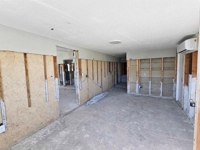 interior space featuring a textured ceiling and a wall mounted AC