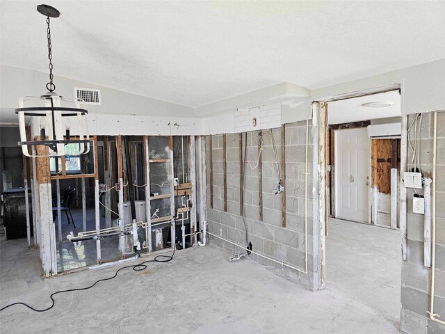 interior space with a textured ceiling and an AC wall unit