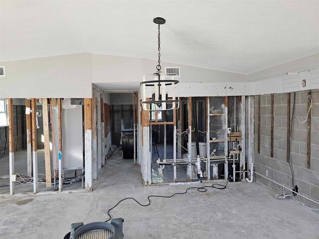 interior space with a textured ceiling, concrete flooring, and lofted ceiling