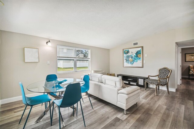 living room with wood-type flooring and vaulted ceiling