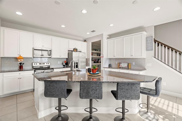 kitchen with sink, a spacious island, a kitchen bar, and stainless steel appliances