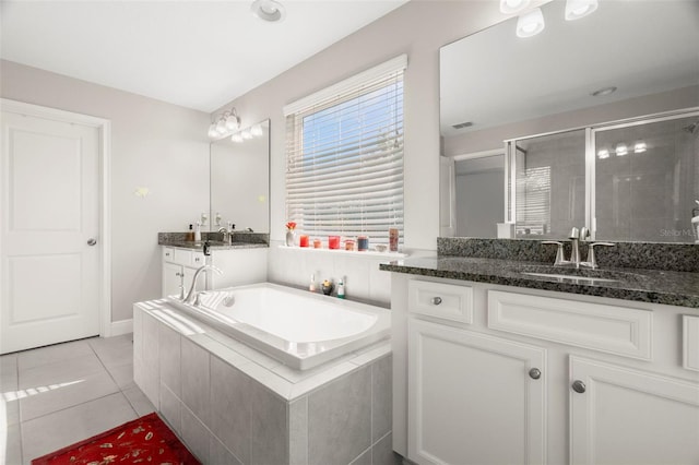 bathroom with tile patterned floors, vanity, and shower with separate bathtub