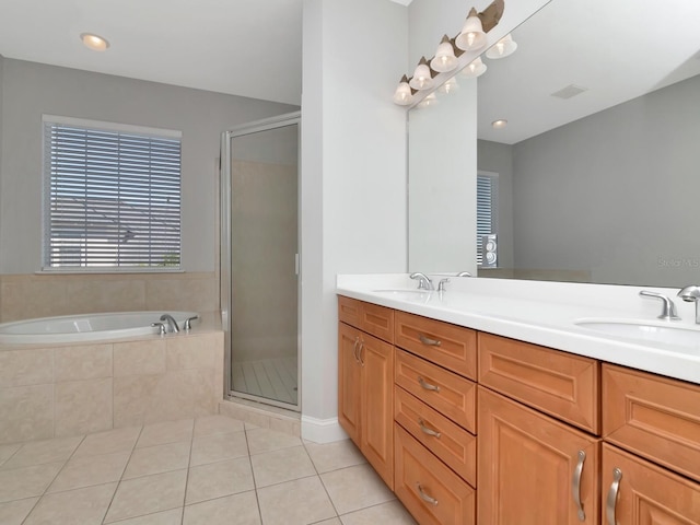 bathroom with plus walk in shower, tile patterned flooring, and vanity