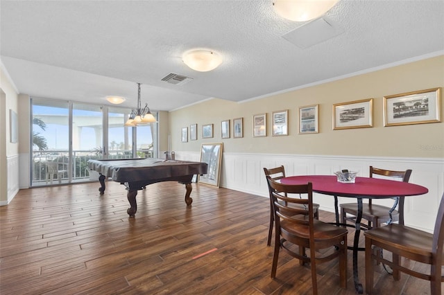 game room featuring a textured ceiling, dark hardwood / wood-style floors, crown molding, and billiards