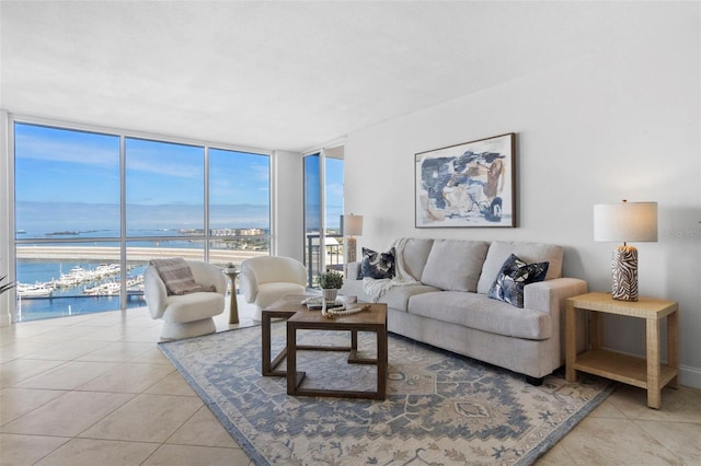 living room with light tile patterned floors, a water view, and expansive windows