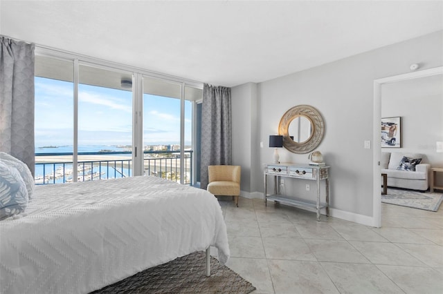 tiled bedroom with floor to ceiling windows, a water view, and access to exterior