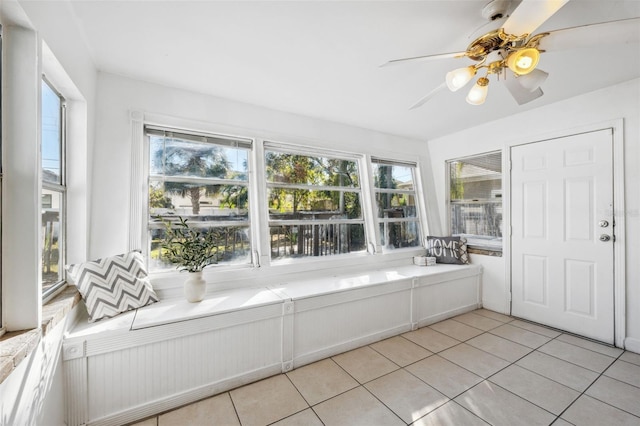 unfurnished sunroom featuring ceiling fan