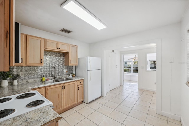 kitchen featuring sink, light brown cabinets, tasteful backsplash, white appliances, and light tile patterned floors