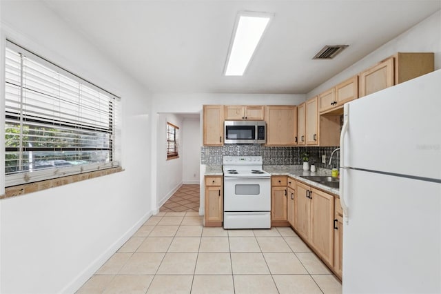 kitchen featuring light brown cabinets, white appliances, and sink