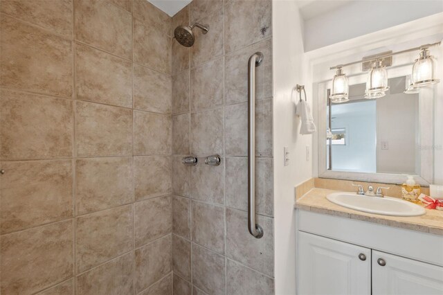 bathroom featuring tiled shower and vanity