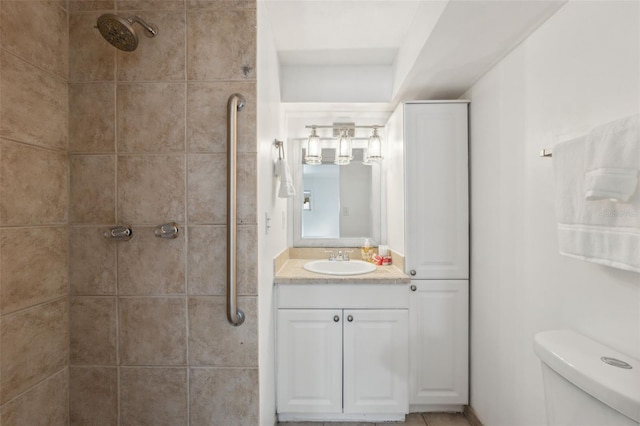 bathroom featuring vanity, toilet, and tiled shower