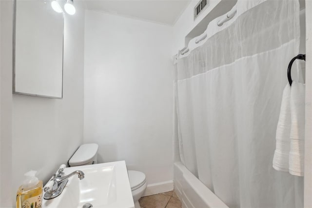 full bathroom with tile patterned floors, shower / bath combo with shower curtain, sink, and toilet