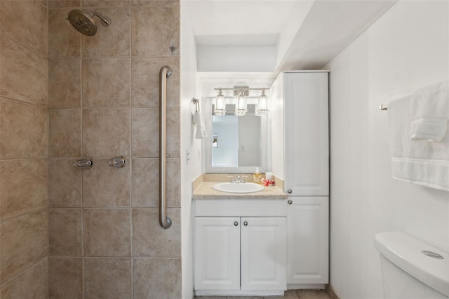 bathroom with toilet, vanity, and a tile shower