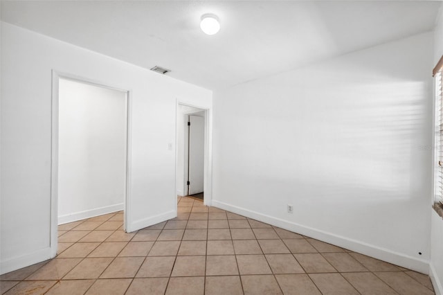 spare room with baseboards, visible vents, and light tile patterned floors