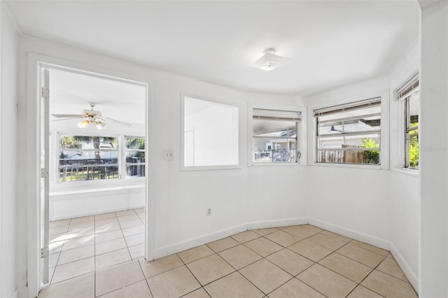 spare room with ceiling fan, baseboards, and light tile patterned floors