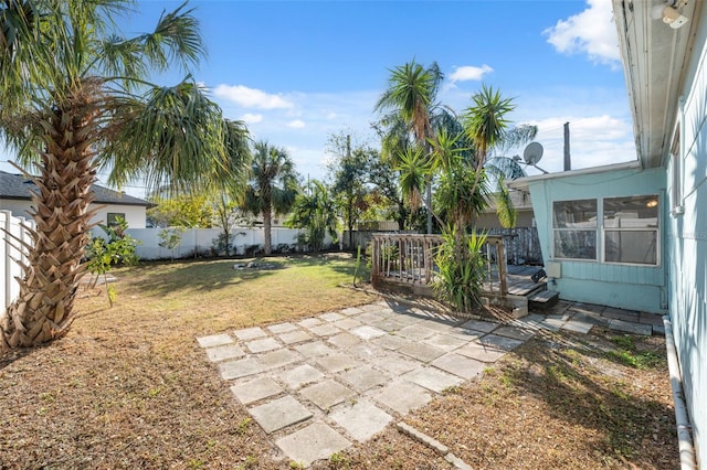 view of yard featuring a wooden deck, a fenced backyard, and a patio