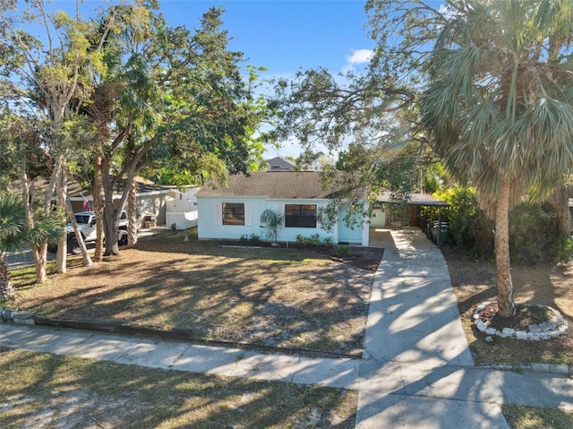 view of front of property with concrete driveway and an attached carport