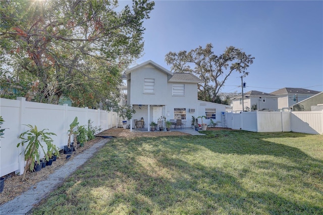 rear view of property featuring a patio and a lawn