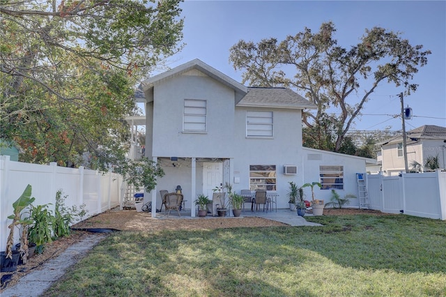 back of property featuring a lawn, an AC wall unit, and a patio