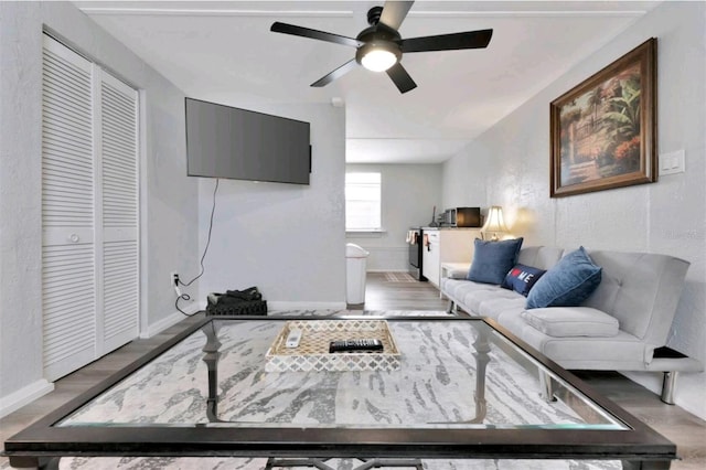 living room featuring hardwood / wood-style floors and ceiling fan