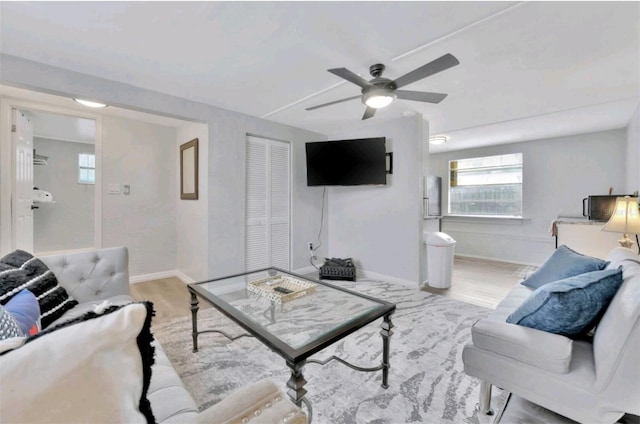 living room with light hardwood / wood-style flooring and ceiling fan