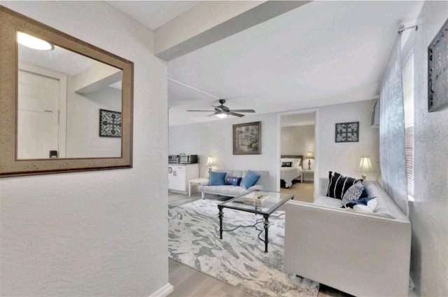 living room with ceiling fan and light hardwood / wood-style flooring