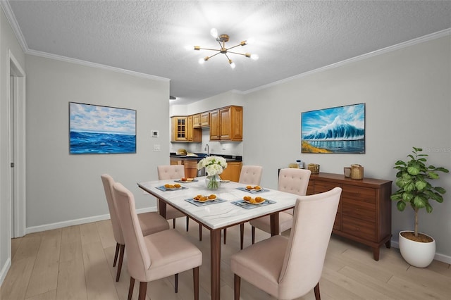 dining room featuring a notable chandelier, ornamental molding, a textured ceiling, and light wood-type flooring