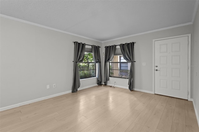 empty room with ornamental molding, a textured ceiling, and light hardwood / wood-style flooring