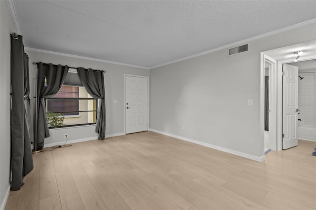 unfurnished room with ornamental molding, a textured ceiling, and light hardwood / wood-style flooring