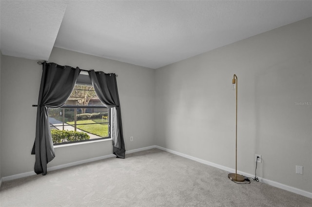 unfurnished room with carpet and a textured ceiling