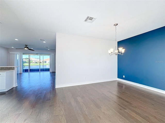 spare room with wood-type flooring and ceiling fan with notable chandelier