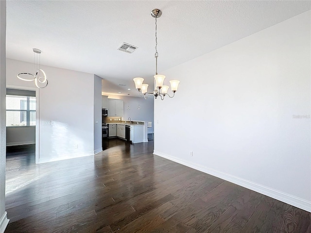 interior space with a textured ceiling, dark hardwood / wood-style flooring, an inviting chandelier, and sink