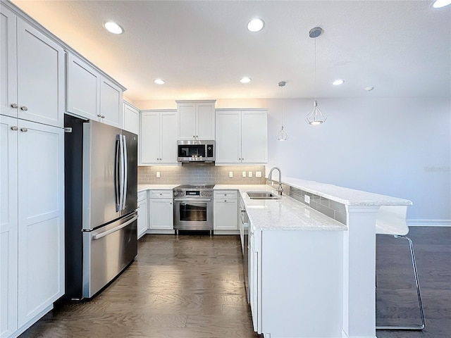 kitchen featuring white cabinets, sink, hanging light fixtures, dark hardwood / wood-style floors, and stainless steel appliances